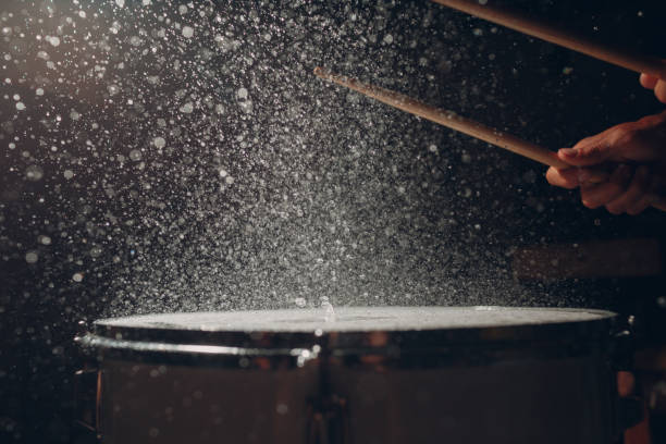 istock Drum sticks drumming beat rhythm on drum surface with splash water drops 1337335624