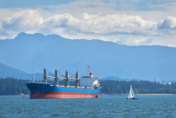 An anchored freighter and sailboat in English Bay.