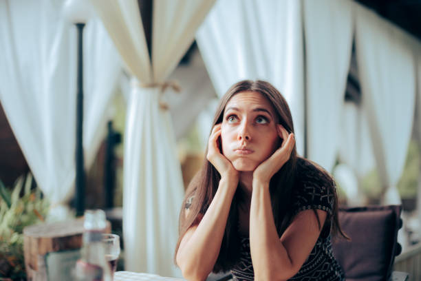 Bored Girlfriend Waiting for her Date in a Restaurant Unhappy young woman sitting at an anniversary party event guest stock pictures, royalty-free photos & images