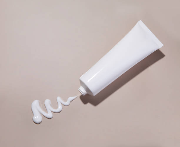 Cosmetic cream tube and stroke on beige background stock photo