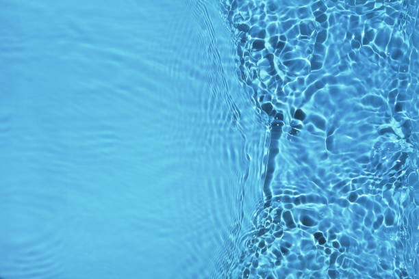 istock Transparent blue water surface with ripples and splashes. Summer water waves background in sunlight. 1337358450