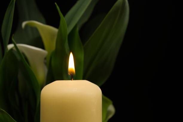 istock Candle burning flame in the darkness and arum lilies 1337370531
