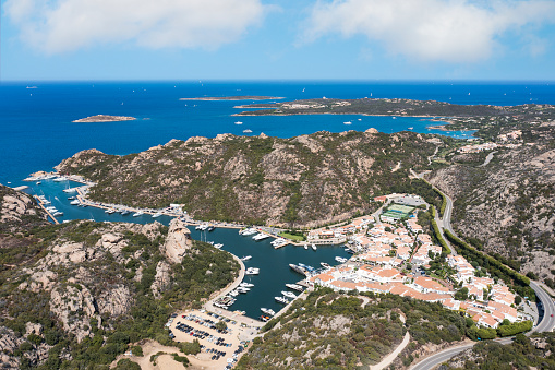 View from above, stunning aerial view of the village of Poltu Quatu with its beautiful harbour full of boats and luxury yachts. Sardinia, Italy.