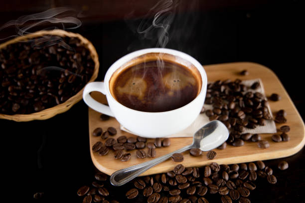 istock coffee cup with smoke, a spoon and coffee beans placed on a small basket beside it. 1337372069