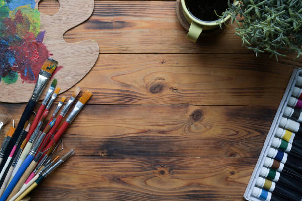 istock Creative workspace with paint brushes, watercolors and palette on wooden table. 1337372284