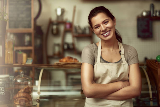 portrait d’une jeune femme confiante travaillant dans un café - premier emploi photos et images de collection
