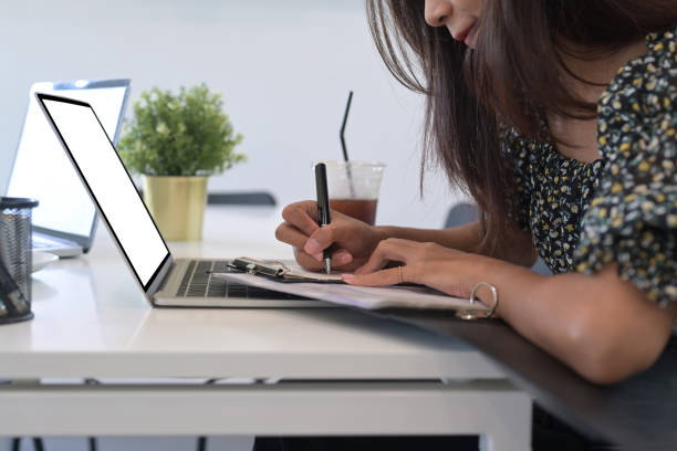 istock Cropped shot female designer working with computer laptop and making note on notebook. 1337373263