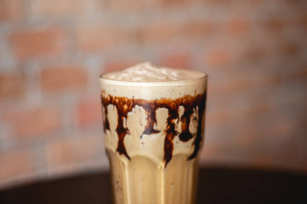 istock Ice coffee and chocolate on a wood table with brick wall background. 1337374152