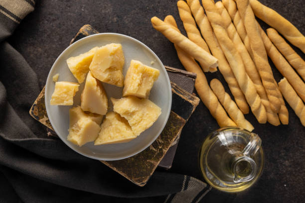 Grissini sticks and parmesan cheese. Traditional italian food. Grissini sticks and parmesan cheese. Traditional italian food on black table. Top view. grana padano stock pictures, royalty-free photos & images