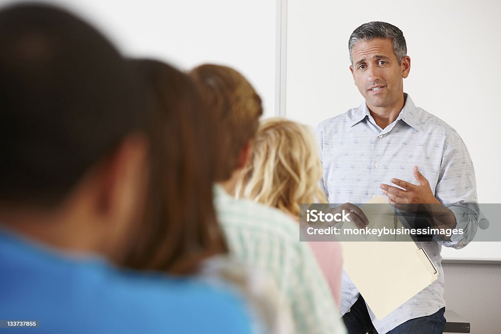 Tutor with class of students Tutor talking in front of class of university students Classroom Stock Photo