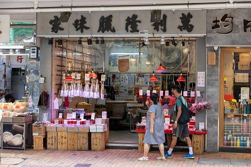 Hong Kong - August 30, 2021 : People walk past the dried Chinese sausage store in Des Voeux Road West, Sai Ying Pun, Hong Kong.
