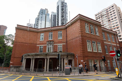 Hong Kong - August 30, 2021 : People walk past the King's College in Bonham Road, Mid-levels, Hong Kong.