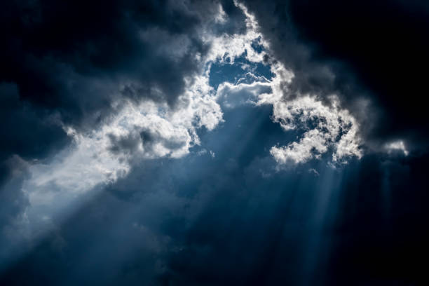istock Bright rays of sun make their way through dark cloud. 1337381201