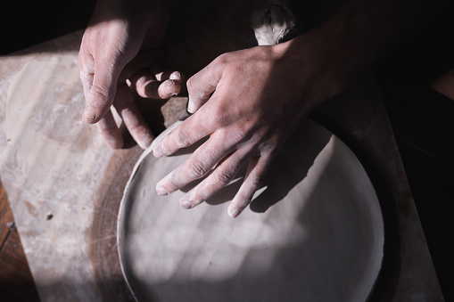 The process of making ceramic plate, man pinching clay