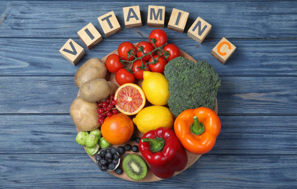 istock Cubes with phrase VITAMIN C and fresh products on blue wooden table, flat lay 1337387468