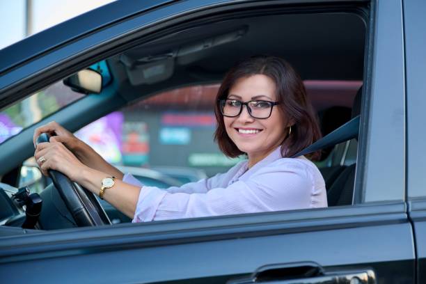 istock Middle-aged beautiful woman driver driving a car 1337387495