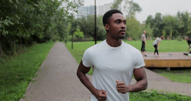 istock Active african american man runner training alone, running in empty city park. Morning workout. Concept of healthy lifestyle. 1337387614