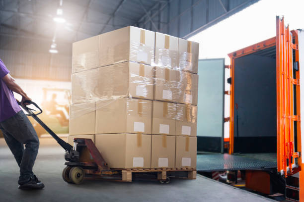 istock Worker Courier Unloading Package Box Out Of Cargo Container. Delivery service. Truck Loading at Dock Warehouse. Shipments. Shipping Warehouse Logistics and Transportation. 1337396504