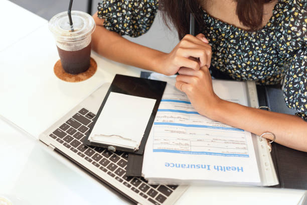 Closeup workspace of insurance broker, laptop, health insurance information form on desk Health insurance agent concept, closeup workspace of insurance broker, laptop computer, health insurance information form, coffee on desk health insurance stock pictures, royalty-free photos & images