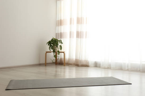 istock Unrolled grey yoga mat on floor in room 1337401549