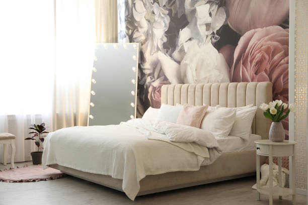 istock Beautiful room interior with large bed, mirror and floral pattern on wall 1337401811