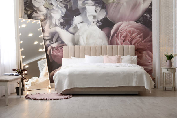 istock Beautiful room interior with large bed, mirror and floral pattern on wall 1337401830