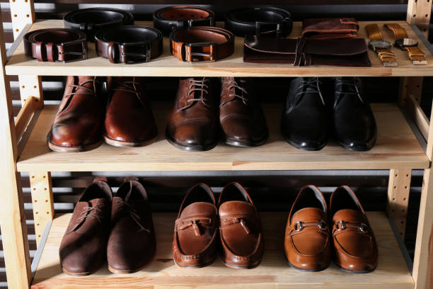 istock Wooden shelving unit with different leather shoes and belts 1337401871