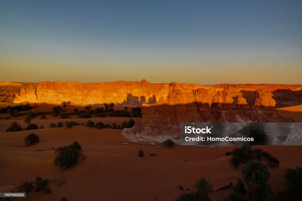 Sunrise at sandstone formation in the Sahara desert near Yoa Lake group of Ounianga Kebir, Ennedi, Chad Sunrise at sandstone formation in the Sahara desert near Yoa Lake group of Ounianga Kebir in Ennedi, Chad Chad - Central Africa Stock Photo