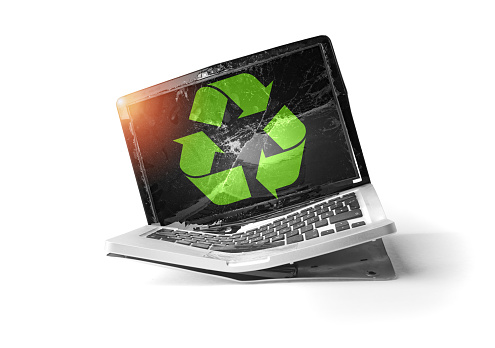 Old disposed of e-waste laptop with recycle symbol. Ecology concept