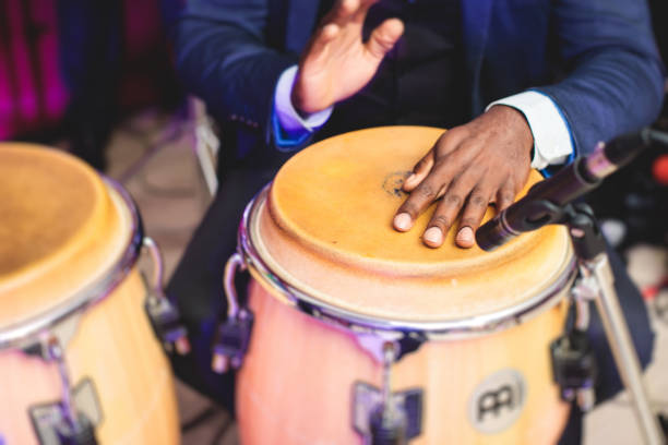 istock Bongo drummer percussionist performing on a stage with conga drums set kit during jazz rock show performance, with latin cuban band performing in the background, drummer point of view 1337403251