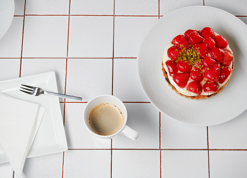 Flat lay coffee and cake on tiled table. Background image with copy space