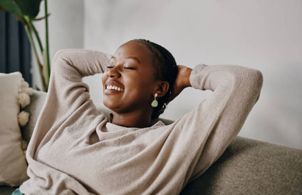 shot of a young woman relaxing on the sofa at home - folga imagens e fotografias de stock