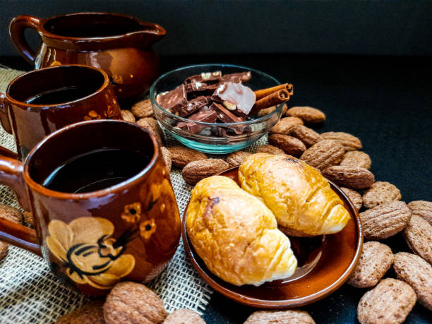istock Coffee in a small brown mugs with cinnamon, croissants for one on a dark background 1337407284
