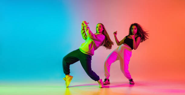 istock Two beautiful talented hip-hop dancers on colorful gradient background in neon lights 1337407433