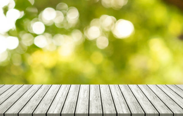 istock White wooden table on outdoor forest blurred background. 1337408429