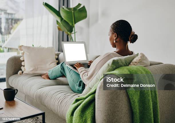 Shot Of A Young Woman Working On Her Laptop On The Couch At Home Stock Photo - Download Image Now