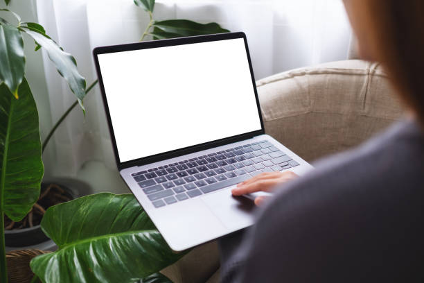 Mockup image of a woman using and working on laptop computer with blank desktop screen at home stock photo