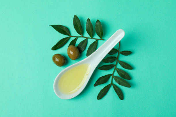 istock Spoon with oil, olives and twigs on mint background 1337409135