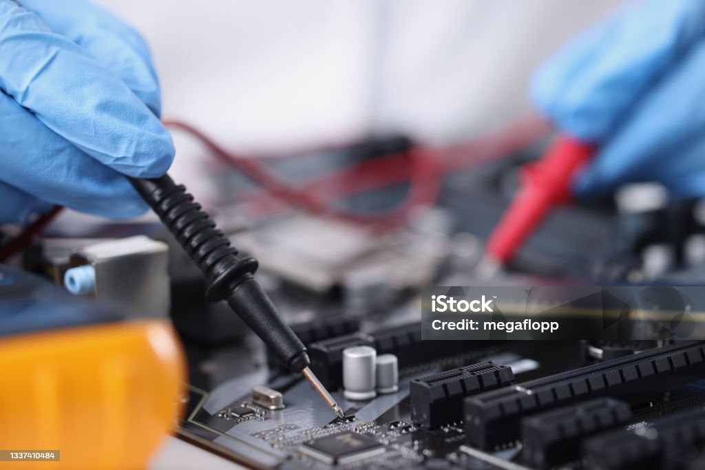 Master in gloves with equipment is testing computer motherboard Master in gloves with equipment is testing computer motherboard. Computer equipment repair concept Assistance Stock Photo