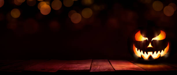 istock A scary halloween lantern with evil eyes and face on a rustic wood table. 1337410611