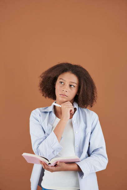 istock Pensive Girl Writing in Diary 1337410875