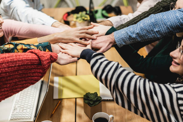 istock Happy young teamwork celebrating together stacking hands inside startup office - Focus on hands 1337410992