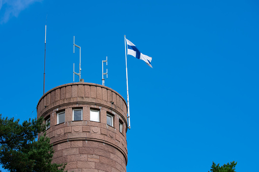 Viewing deck of Pyynikki observation tower with Finnish flag on a clear summer day in Tampere, Finland.