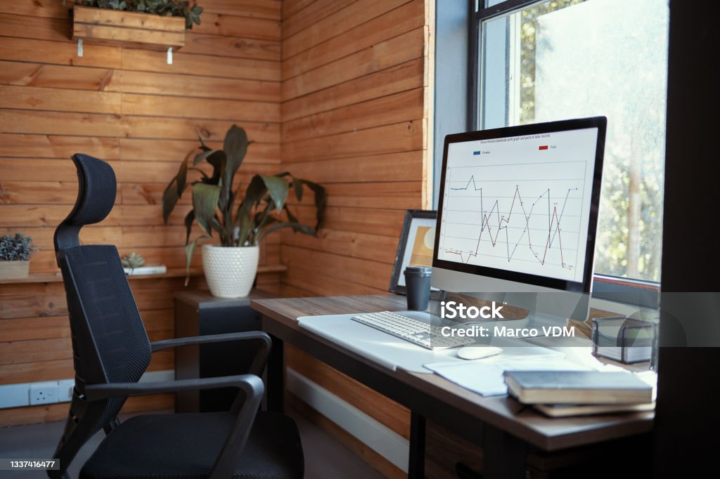 Shot of furniture and technology in an empty office during the day Never skip a day of looking at business data Desktop PC Stock Photo