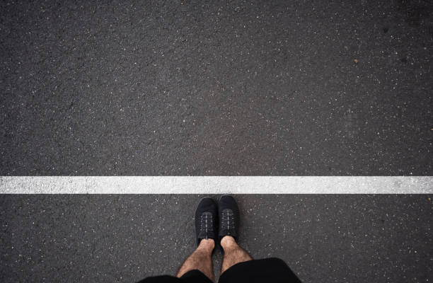 istock Man waiting on white line on asphalt 1337420155