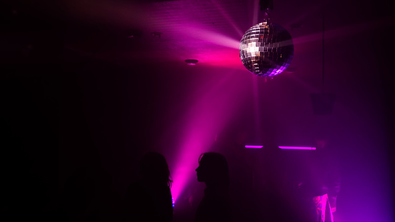 Party atmosphere with disco ball. Light beams reflecting from a disco ball.