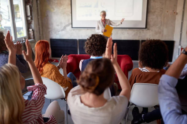 group of people clapping hands to an elderly female having a successful presentation. group of people clapping hands to an elderly female having a successful presentation. selective focus image working seniors stock pictures, royalty-free photos & images