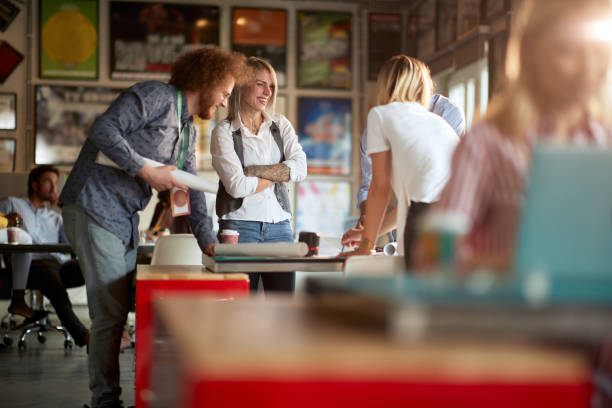 istock group of people gathered around the table, standing, smiling, talking, laughing. fun at work concept. 1337422128