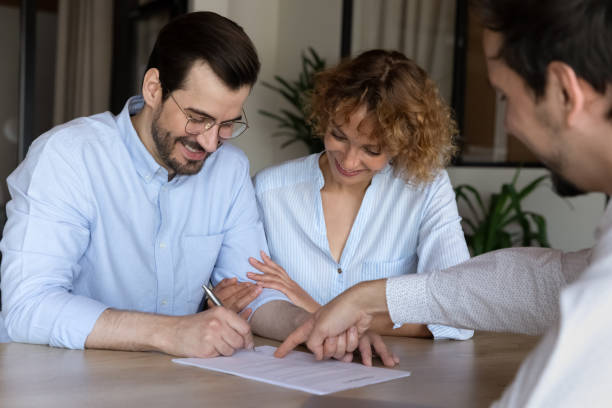 istock Smiling couple sign document at office meeting 1337424319