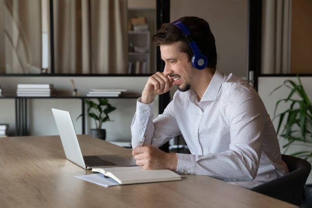 istock Happy male employee work distant on laptop taking notes 1337424342